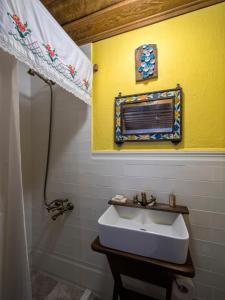 a bathroom with a sink and a yellow wall at Yeni Gelin Evi in Birgi