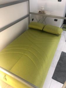ein grünes Bett in einem Zimmer mit einem Tisch in der Unterkunft Hamlet appartment in Neapel