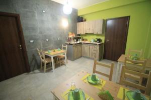 cocina con paredes verdes, mesa y sillas en Il Rifugio degli Artisti en Varese