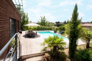 - une piscine avec une terrasse et un parasol dans l'établissement Les Crays de Levigny, à Charnay-lès-Mâcon