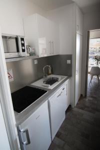 - une cuisine avec un évier et un comptoir dans l'établissement 5 avenue de la Gavine Résidence Hyères Parc, à Hyères