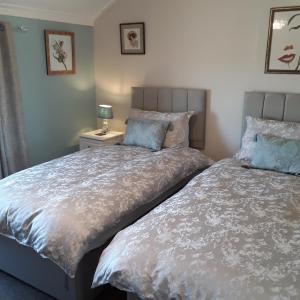 twee bedden naast elkaar in een slaapkamer bij Kingsleigh Guest House in Lowestoft