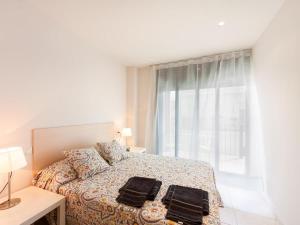 a bedroom with a bed with two black towels on it at Apartamentos TDM in Tossa de Mar