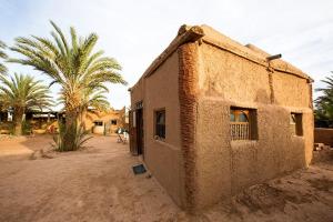 an old building in the middle of a desert at Chez Madani in Mhamid