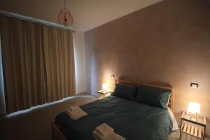 a bedroom with a large bed with two lamps on it at Il Rifugio degli Artisti in Varese