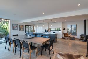 a kitchen and dining room with a wooden table and chairs at Panorama House by Sotheby's Luxury Rental Homes in Queenstown