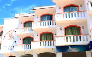 un edificio con balcones rojos y blancos. en Beach Balance, en Playa del Carmen