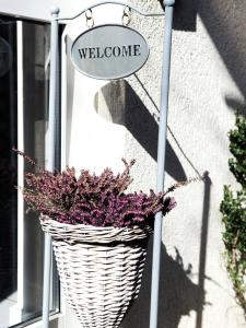 - un panier en osier avec un panneau de bienvenue devant une porte dans l'établissement Boutique Hotel Villa Stockum, à Düsseldorf