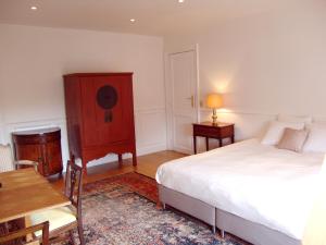 een slaapkamer met een bed, een dressoir en een tafel bij Louise Chatelain suites in Brussel