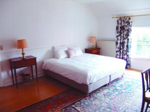 a bedroom with a bed and two tables and a window at Louise Chatelain suites in Brussels