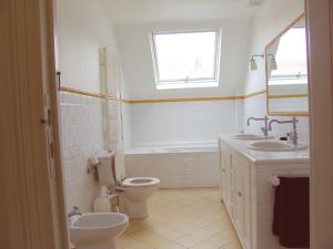 a bathroom with a toilet and a sink and a tub at Louise Chatelain suites in Brussels