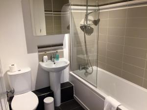 a bathroom with a toilet and a sink and a shower at City Centre Belfast Free Parking in Belfast +19 photos