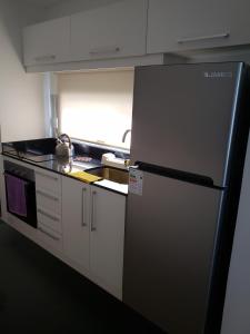 a kitchen with a stainless steel refrigerator in a kitchen at Edificio Paquebot, en Peninsula, con vista al mar in Punta del Este