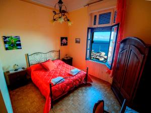 a bedroom with a red bed and a window at Barone Bed and Breakfast in Salerno