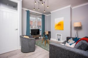 a living room with two chairs and a television at Dene View By Horizon Stays in Darlington