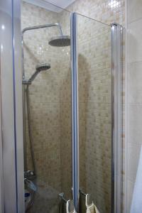 een douche met een glazen deur in de badkamer bij Peniche4you in Peniche