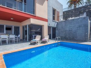 a swimming pool with two chairs next to a house at Villa entera - incredible PRICE Luxury Villa Puerto De la Cruz in Santa Úrsula