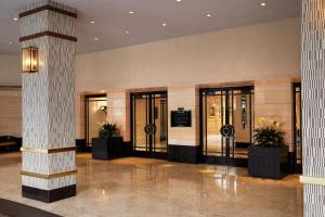 un vestíbulo con puertas de cristal y macetas en The London West Hollywood at Beverly Hills, en Los Ángeles