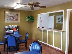 un restaurant avec une table et des chaises ainsi qu'un bar dans l'établissement Stay Inn Checotah, à Checotah