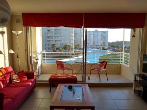 a living room with a couch and a view of a pool at Condominio Laguna Vista Camino Casablanca 788 Algarrobo in Algarrobo