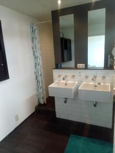 a bathroom with two sinks and a mirror at Harmony House in Antwerp