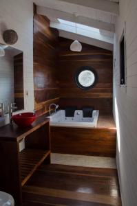 a bathroom with a sink and a clock on the wall at Norwood Eco Cabañas in Punta Del Diablo