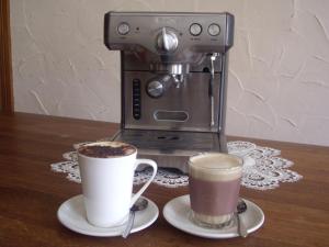 a espresso machine and two cups of coffee on a table at Lucinda B&B in Latrobe