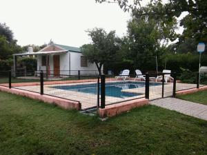 a fence around a swimming pool in a yard at Complejo Leon in Villa Rumipal
