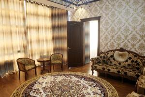 een woonkamer met een bank en een tafel en stoelen bij Hotel Naxshab in Qarshi
