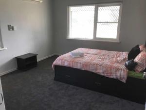 1 dormitorio con cama y ventana en Maddington House Unit A, en Perth