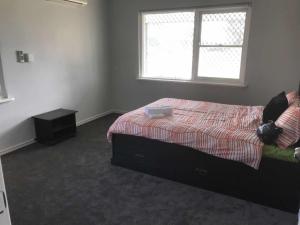 a bedroom with a bed and a window at Maddington House Unit A in Perth
