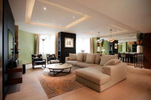 uma sala de estar com um sofá e uma mesa em City Viva Hotel Macau-Fomerly Hotel Million Dragon Macau em Macau