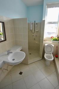 a bathroom with a sink and a toilet and a shower at Sandakan Puteri Indah House in Sandakan