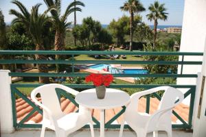 a balcony with a table and two chairs and a pool at Classic Apartments in Hersonissos