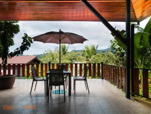 a table and chairs with an umbrella on a patio at Cyana Resort in Wok Tum