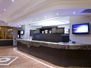 a lobby with a bar with a flat screen tv at Hotel Ca' Brugnera in Brugnera