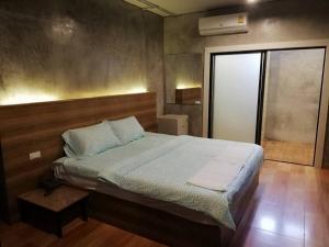 um quarto com uma cama grande e uma janela em Sands Place Apartment and Hotel em Samut Sakhon