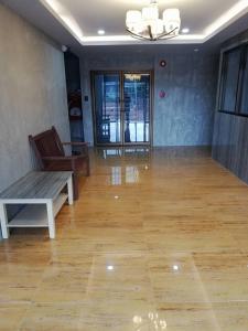 a living room with a wooden floor and a bench at Sands Place Apartment and Hotel in Samut Sakhon