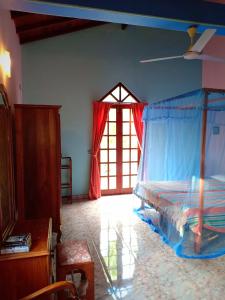 希卡杜瓦的住宿－HikkaSurf Apartment，一间卧室设有天蓬床和窗户。