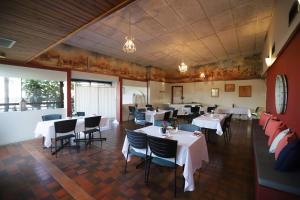 jadalnia z białymi stołami i krzesłami w restauracji w obiekcie Emerald Central Hotel Official w mieście Emerald