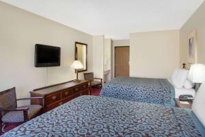 a hotel room with two beds and a television at Days Inn by Wyndham Jackson in Jackson