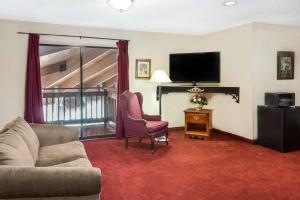 a living room with a couch and a flat screen tv at Days Inn by Wyndham Jackson in Jackson