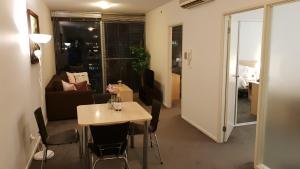 墨爾本的住宿－2 bedrooms CBD FREE Tram apartment (Melb Central, China Town, Queen Victoria Market, Melbourne University, RMIT, etc)，一间带桌椅的房间和一间客厅