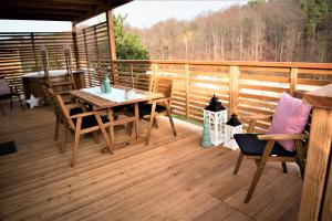 a wooden deck with a table and chairs on it at Glamping SUN VALLEY Bioterme in Mala Nedelja
