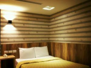 高雄的住宿－儂來旅館，一间卧室配有一张床和条纹墙