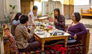 a group of people sitting around a table eating food at Amulet Hotel in Bukhara