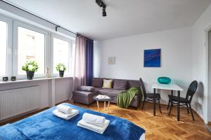 ein Wohnzimmer mit einem Sofa und einem Tisch in der Unterkunft Noctis Apartment Plac Grzybowski in Warschau