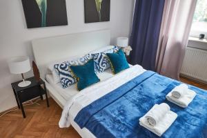 ein Schlafzimmer mit einem Bett mit Handtüchern darauf in der Unterkunft Noctis Apartment Plac Grzybowski in Warschau