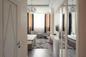 a room with a bedroom with a table and a mirror at Hotel Park Avenue in Astana