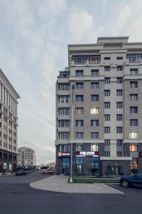 duży budynek z samochodem zaparkowanym przed nim w obiekcie Hotel Park Avenue w mieście Astana